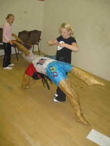 Workshop leader making willow sculptures of local olympians with children on summer school in Bridgend